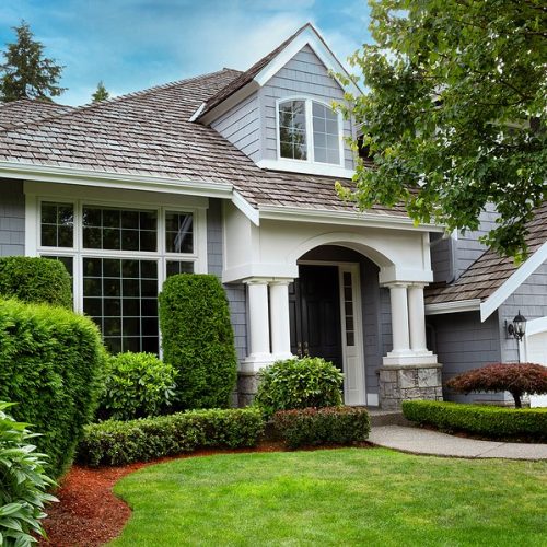 Close up view of a modern home with cedar shake roof during summer time